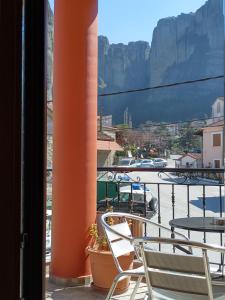 balcón con mesa, sillas y vistas a la montaña en Guesthouse Lithos, en Kalambaka