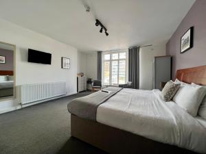 a bedroom with a large bed and a television at Starboard Stays in Southampton