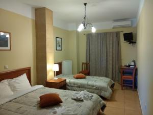 a hotel room with two beds and a desk at Guesthouse Lithos in Kalabaka