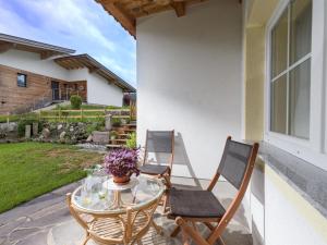 a patio with two chairs and a table with at Appartement Erika in Hopfgarten im Brixental +4 photos