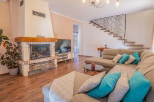 a living room with a couch and a fireplace at Amazing 4 bedroom villa with Swimming pool and WIFI, family frendly in Tribalj