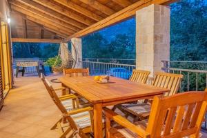 a wooden table and chairs on a porch at Amazing 4 bedroom villa with Swimming pool and WIFI, family frendly in Tribalj