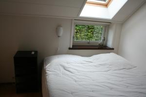 um quarto com uma cama branca e uma janela em Bed & Breakfast Ter Borg em Sellingen