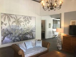 un soggiorno con divano e un dipinto sul muro di La Sucrerie, magnifique villa avec Piscine a Sainte-Anne