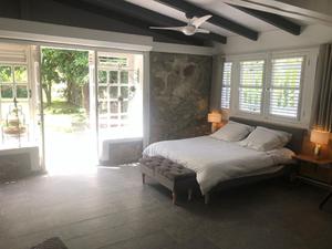 1 dormitorio con 1 cama y ventilador de techo en La Sucrerie, magnifique villa avec Piscine, en Sainte-Anne