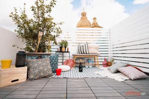 a patio with lots of pillows and plants on it at A modern Maltese townhouse in Siggiewi in Siġġiewi