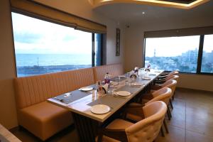 HOTEL THE GRANDLADHUKARA في دواركا: غرفة طعام طويلة مع طاولة وكراسي طويلة