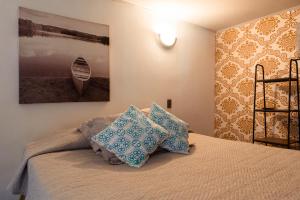 a bedroom with a bed with blue pillows on it at Hostal Casa de Huéspedes 269 in Santiago