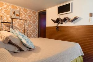 1 dormitorio con 1 cama y TV en la pared en Bella 269, en Santiago