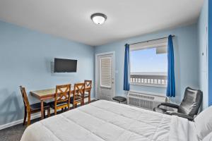 a bedroom with a bed and a table and chairs at The Sand Dunes in Kure Beach