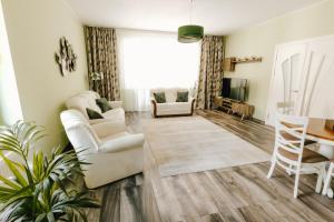 a living room with white furniture and a table at Vila Bucium Club in Iaşi