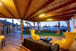 a living room with a couch and chairs on a deck at Anda Beach Bistro & Rooms in Cunda +24 photos