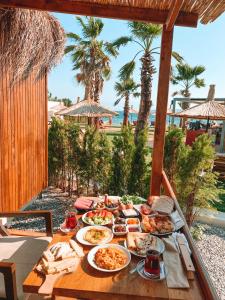 una mesa con comida y vistas a la playa en Anda Beach Bistro & Rooms en Cunda