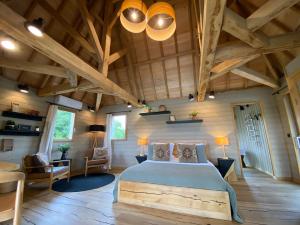 1 dormitorio con 1 cama en una habitación con techos de madera en Châteaux dans les Arbres, en Clottes