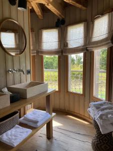 baño con lavabo, espejo y ventanas en Châteaux dans les Arbres, en Clottes
