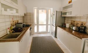 a kitchen with white cabinets and a sink at Vila Bucium Club in Iaşi