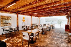 un restaurante con mesas y sillas en una habitación en Anda Beach Bistro & Rooms en Cunda
