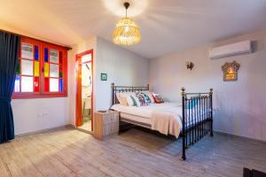 1 dormitorio con cama y lámpara de araña en Anda Beach Bistro & Rooms en Cunda