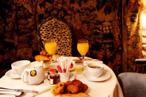 een tafel met eten en twee glazen sinaasappelsap bij Hôtel Bourg Tibourg in Parijs