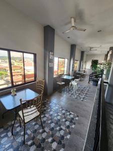 - une salle à manger avec des tables, des chaises et des fenêtres dans l'établissement New Kong's Hotel, à Olongapo