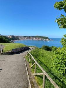 a wooden fence next to a road next to a body of water at Southcliff Retreat in Scarborough