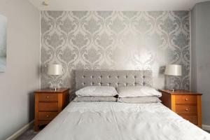 a bedroom with a bed with two nightstands and two lamps at Southcliff Retreat in Scarborough