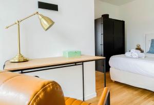 Schlafzimmer mit einem Schreibtisch, einem Bett und einer Lampe in der Unterkunft Albatros in Annecy