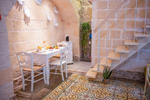 - une cuisine avec une table et des chaises dans la chambre dans l'établissement [Borgo Antico-Centro Storico] Casa Ventosa, à Oria