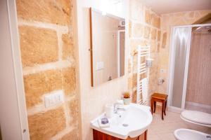 La salle de bains est pourvue d'un lavabo, de toilettes et d'un miroir. dans l'établissement [Borgo Antico-Centro Storico] Casa Ventosa, à Oria