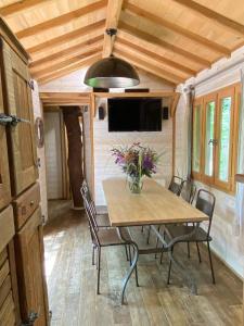 - une salle à manger avec une table et des chaises dans une petite maison dans l'établissement Châteaux dans les Arbres, à Clottes