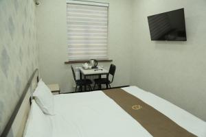 タシュケントにあるPremium Hotel 777のベッドルーム(ベッド1台、テーブル、テレビ付)