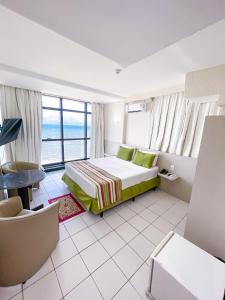 a bedroom with a bed and a view of the ocean at Hotel Golden Park Recife Boa Viagem in Recife