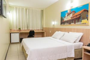 a hotel room with a large bed and a chair at Hotel Express Arrey - Teresina in Teresina