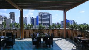 een patio met tafels en stoelen en uitzicht op de stad bij IVY Hotel Addis Ababa Airport branch in Addis Ababa