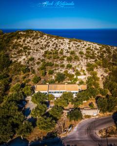een gebouw aan de kant van een heuvel naast de oceaan bij Sofia and Soul Studios in Kalamitsi