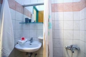 uma casa de banho com um lavatório e um espelho em Sofia Studios Kathisma em Kalamitsi