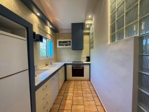 a kitchen with white cabinets and a tile floor at Villas El Pinaret - Serviden in Pedreguer