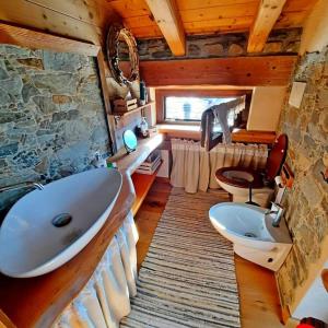 a bathroom with a large tub and a sink at Baita Il Focolare - Your Mountain Holiday in Premana
