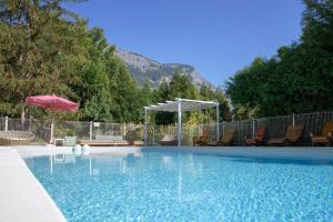 piscina con sedie e ombrellone di Sport'Hotel-Aparthotel de Milan a Le Bourg-dʼOisans