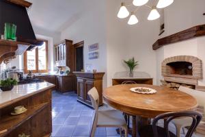 cocina con mesa de madera y chimenea en Mamo Florence - Pisana Apartment, en Florencia