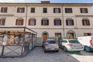 dos coches estacionados frente a un gran edificio en Mamo Florence - Pisana Apartment, en Florencia