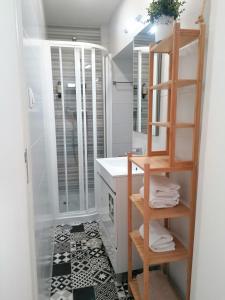 La salle de bains est pourvue d'un lavabo, d'un miroir et d'une étagère. dans l'établissement Lisboa Bridge Spot, à Lisbonne