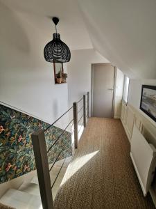 eine Treppe mit einem Glasgeländer und einer Wand mit einem Wandbild in der Unterkunft Au numéro Cinq in Donville-les-Bains