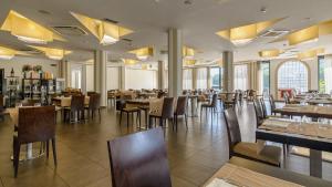 Hotel Terme Capasso في كونتورسي: غرفة طعام مع طاولات وكراسي ونوافذ