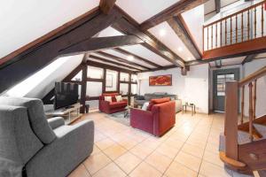 Una sala de estar con sofás y un televisor de pantalla plana. en Les Lionceaux, 120m2 à Colmar, place de parking gratuite, en Colmar