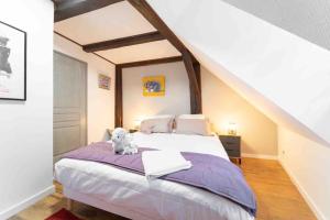 Un dormitorio con una cama con un osito de peluche sentado en ella. en Les Lionceaux, 120m2 à Colmar, place de parking gratuite, en Colmar