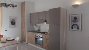 a kitchen with gray cabinets and a stove top oven at LechicchediLampedusa in Lampedusa