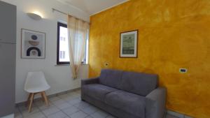 a living room with a couch and a yellow wall at LechicchediLampedusa in Lampedusa