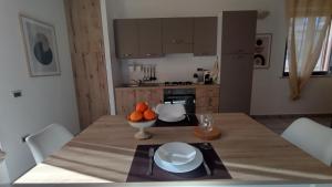 a kitchen with a table with a bowl of oranges on it at LechicchediLampedusa in Lampedusa