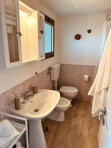 a bathroom with a white sink and a toilet at Agricampeggio La Piaggia - Agriturismo in Piombino